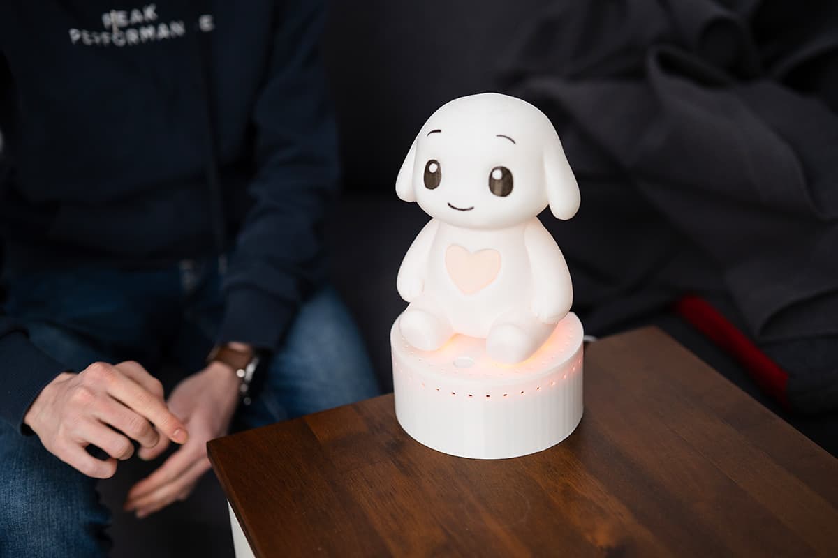 Resident smiling while interacting with Qluve companion robot